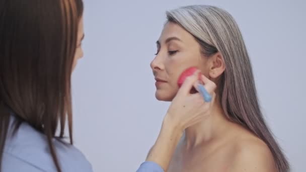 Friendly Young Makeup Artist Correcting Makeup Elderly Calm Woman Photo — Stock Video