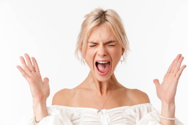 Küpeli, elleri beyaz arka planda izole bir şekilde kusarken çığlık atan güzel, gergin bir kadın görüntüsü.