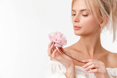 Beyaz arka planda izole edilmiş, çiçeklerle poz veren, güzel, baştan çıkarıcı bir kadın resmi.