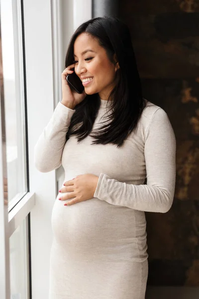 Foto Lycklig Gravid Asiatisk Kvinna Ler Och Talar Mobiltelefon När — Stockfoto