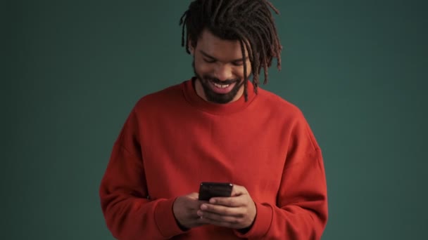 Joven Afroamericano Sonriente Feliz Está Utilizando Teléfono Inteligente Pie Aislado — Vídeos de Stock