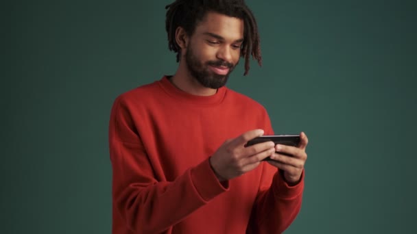 Ένας Όμορφος Νεαρός Αφροαμερικάνος Κρατάει Smartphone Του Οριζόντια Απομονωμένο Πάνω — Αρχείο Βίντεο