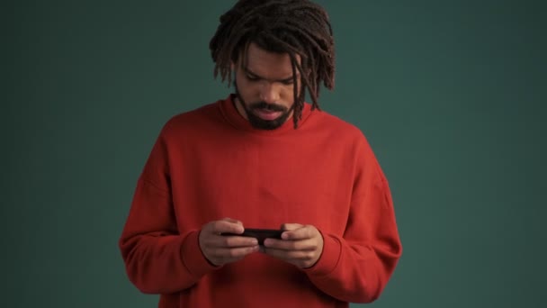 Joven Afroamericano Concentrado Está Jugando Juegos Teléfono Inteligente Pie Aislado — Vídeo de stock