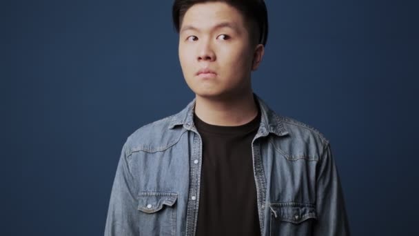Ein Verwirrter Junger Asiatischer Mann Lässiger Kleidung Hebt Seine Schultern — Stockvideo