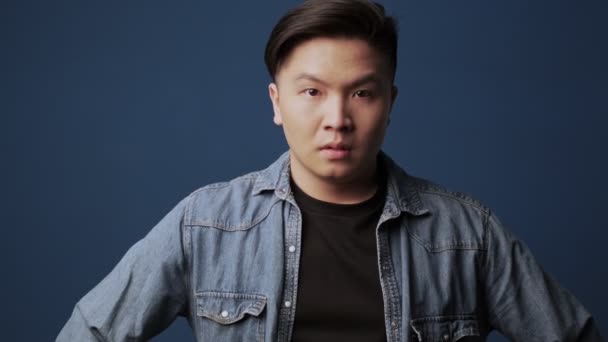 Ulykkelig Alvorlig Asiatisk Mann Med Klær Ser Til Kameraet Isolert – stockvideo