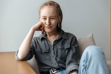 İçeride rastalı poz veren güzel, pozitif gülümseyen genç bir kız resmi..