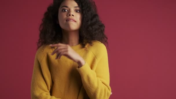 Joven Mujer Africana Concentrada Esperando Aislada Sobre Fondo Rojo Oscuro — Vídeos de Stock