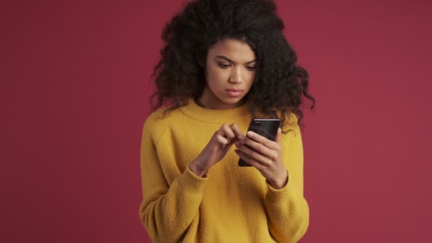 Mujer Seria Africana Joven Aislada Sobre Fondo Rojo Oscuro Borgoña — Vídeos de Stock