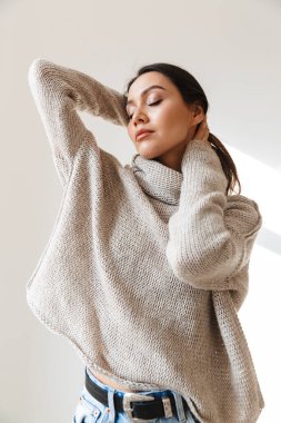 Beyaz arka planda gözleri kapalı poz veren rahat Asyalı kadın görüntüsü