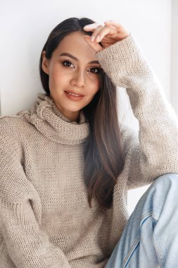 Beyaz arka planda izole edilmiş, poz veren ve kameraya bakan memnun Asyalı kadın görüntüsü