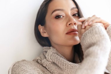 Baştan çıkarıcı Asyalı kadın görüntüsü beyaz arka planda izole edilmiş kameraya poz veriyor ve bakıyor