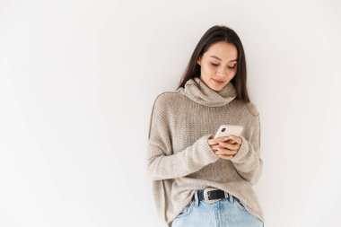 Beyaz arka planda izole edilmiş akıllı telefon kullanan ve poz veren Asyalı bir kadın resmi