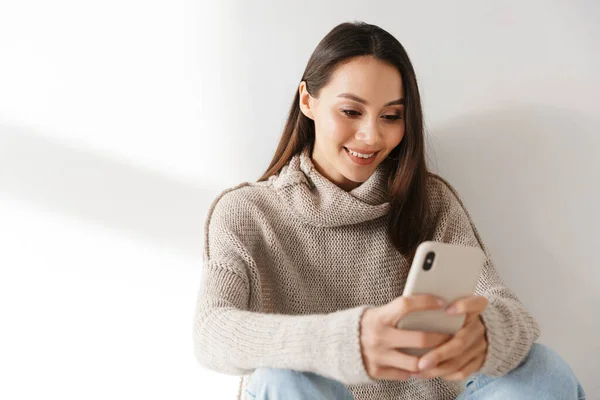 Imagem Mulher Asiática Sorridente Sentado Usando Smartphone Isolado Sobre Fundo — Fotografia de Stock