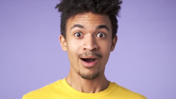 若いアフリカ人ショックを受けた幸せな男隔離された紫の背景 — ストック動画