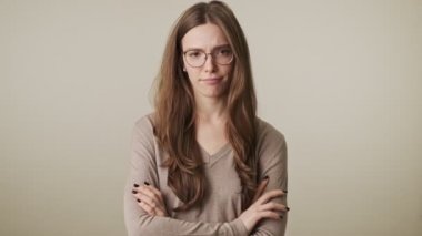 Güzel, genç, hoşnutsuz, güzel bir kadın. Gri duvar arkasında izole edilmiş.