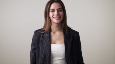 Sıradan kıyafetler giyen mutlu bir kadın stüdyoda beyaz arka planda izole edilmiş iyi bir jest yapıyor.