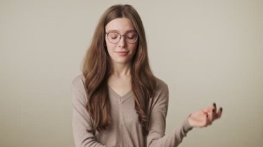 Güzel, genç, gülümseyen güzel bir kadın. Gri duvar arkasında izole edilmiş.