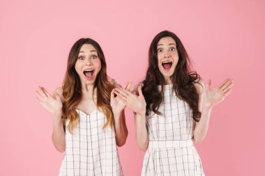 Şaşırtıcı güzellikteki kadınlar pembe arka planda izole edilmiş elleri kusarak şaşkınlıklarını dile getiriyorlar.