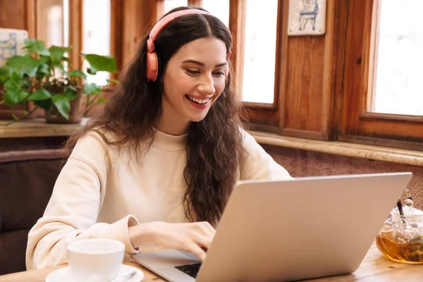 Beeld Van Lachende Vrouw Met Laptop Draadloze Hoofdtelefoon Tijdens Het — Stockfoto