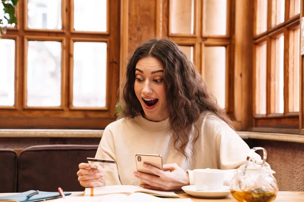 Bild Einer Aufgeregten Frau Mit Handy Und Kreditkarte Beim Teetrinken — Stockfoto