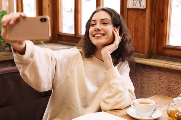 Kafede Çay Içerken Cep Telefonuyla Selfie Çeken Neşeli Beyaz Kadın — Stok fotoğraf