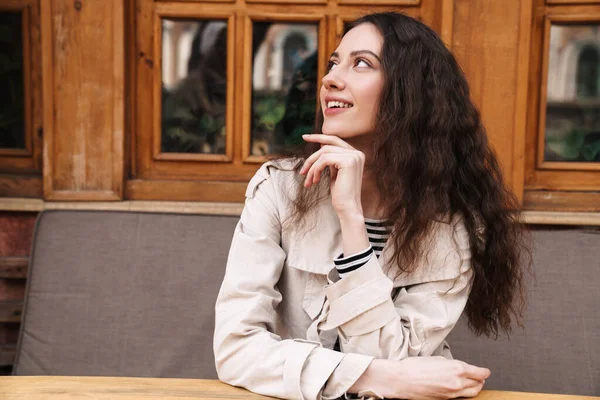 Imagem Mulher Morena Alegre Olhando Para Lado Sorrindo Enquanto Sentado — Fotografia de Stock