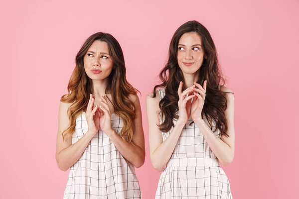 Image of clever young beautiful women thinking and looking aside isolated over pink background