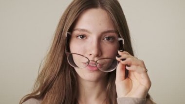 Gri duvar arkaplanından izole edilmiş genç pozitif kadın.