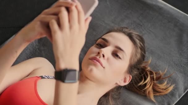 Młoda Dość Skoncentrowana Kobieta Fitness Siłowni Pomocą Telefonu Komórkowego — Wideo stockowe