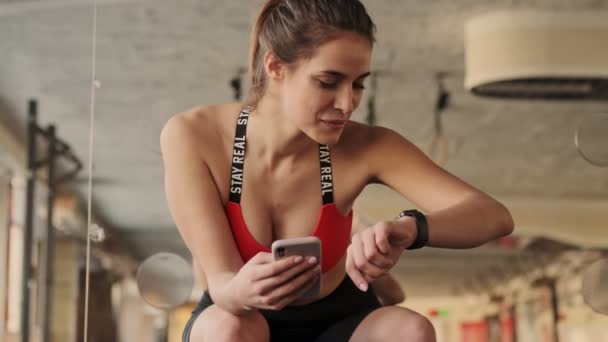 年轻快乐快乐的健身女子在健身房用手机看钟表 — 图库视频影像