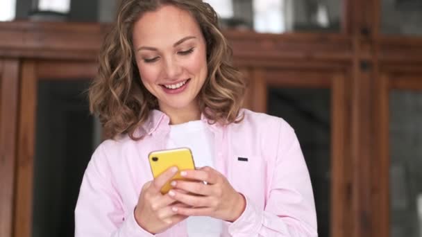 Een Mooie Jonge Blonde Vrouw Gebruikt Haar Smartphone Binnen — Stockvideo