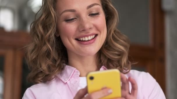Een Verrassende Glimlachende Jonge Blonde Vrouw Kijkt Iets Haar Smartphone — Stockvideo