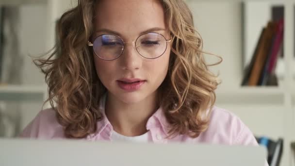 Μια Σοβαρά Εστιασμένη Νεαρή Ξανθιά Γυναίκα Που Φοράει Γυαλιά Εργάζεται — Αρχείο Βίντεο