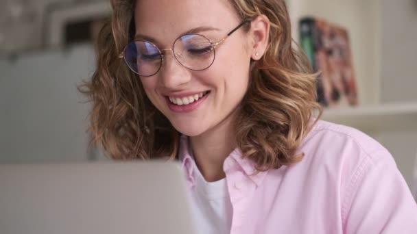 Šťastná Mladá Blondýnka Brýlemi Používá Svůj Notebook Sedí Stolu Uvnitř — Stock video
