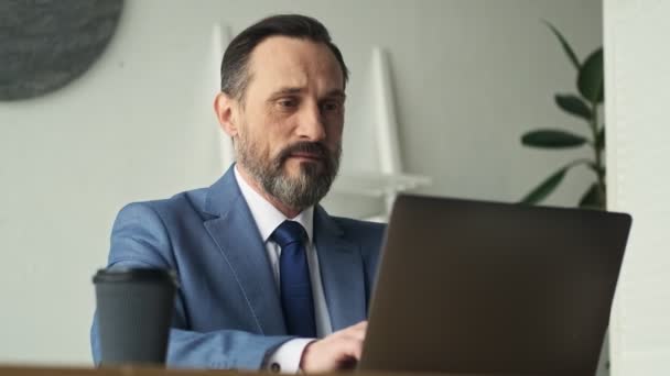 一个成功的成熟男人正在办公室用他的笔记本电脑工作 — 图库视频影像