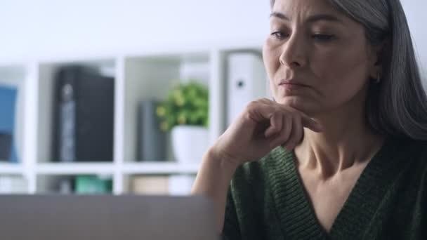 Une Femme Mûre Sérieuse Regarde Son Ordinateur Portable Tout Travaillant — Video