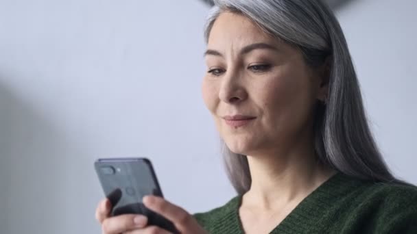 Een Tevreden Volwassen Zakenvrouw Zoek Naar Haar Smartphone Werken Het — Stockvideo