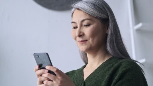 Een Vrolijke Glimlach Volwassen Zakenvrouw Typt Haar Smartphone Tijdens Het — Stockvideo