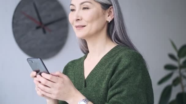 Μια Ευτυχισμένη Γέλιο Ώριμη Επιχειρηματίας Μακριά Γκρίζα Μαλλιά Χρησιμοποιεί Smartphone — Αρχείο Βίντεο