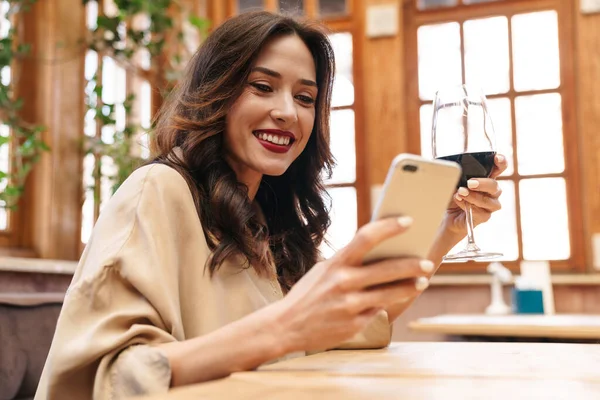 Imagem Mulher Adulta Alegre Bebendo Vinho Tinto Usando Telefone Celular — Fotografia de Stock