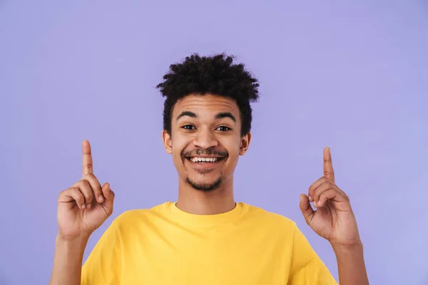 幸せなアフリカ系アメリカ人男性の笑顔と紫色の背景の上に孤立指を指すの写真 — ストック写真