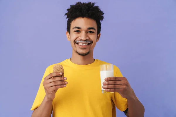 Foto Hombre Afroamericano Contento Sonriendo Mientras Come Galletas Con Leche — Foto de Stock