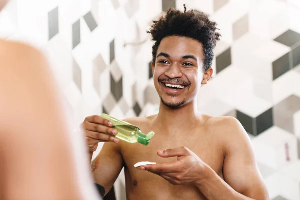Foto Hombre Afroamericano Medio Desnudo Riendo Usando Loción Facial Mirando — Foto de Stock
