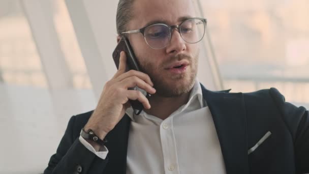 Hombre Negocios Barbudo Joven Guapo Está Hablando Teléfono Inteligente Mientras — Vídeos de Stock