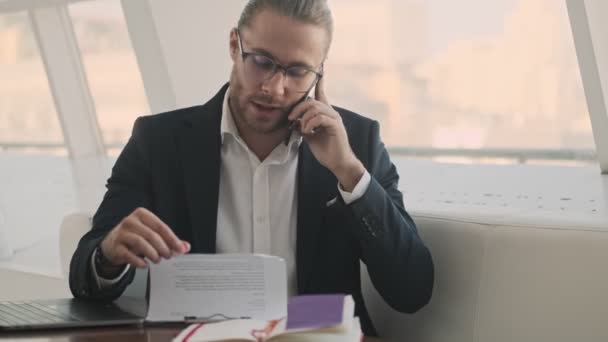 Jovem Empresário Barbudo Confiante Sério Está Falando Seu Smartphone Enquanto — Vídeo de Stock