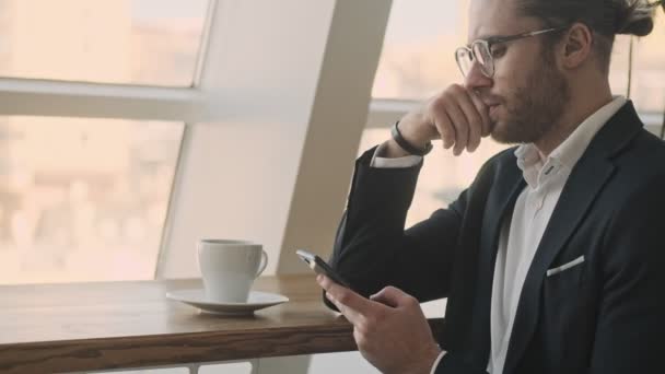 Jistý Seriózní Podnikatel Čte Něco Svém Smartphonu Zatímco Pije Kávu — Stock video