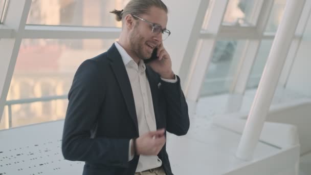 Jovem Empresário Sorridente Feliz Está Falando Seu Smartphone Enquanto Está — Vídeo de Stock