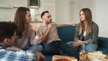 Memnuniyetle gevşemiş bir arkadaş evde oturmuş abur cubur, pizza yiyip bira içerken konuşuyor.