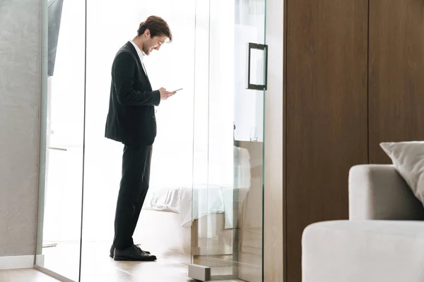 Foto Hombre Negocios Morena Sonriente Con Traje Negro Usando Teléfono — Foto de Stock