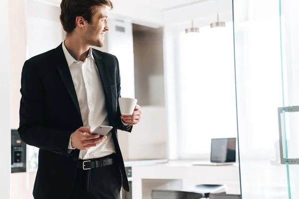 Foto Eines Zufriedenen Brünetten Geschäftsmannes Schwarzen Anzug Der Kaffee Trinkt — Stockfoto